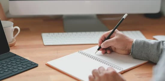 Persona escribiendo en un cuaderno en blanco.